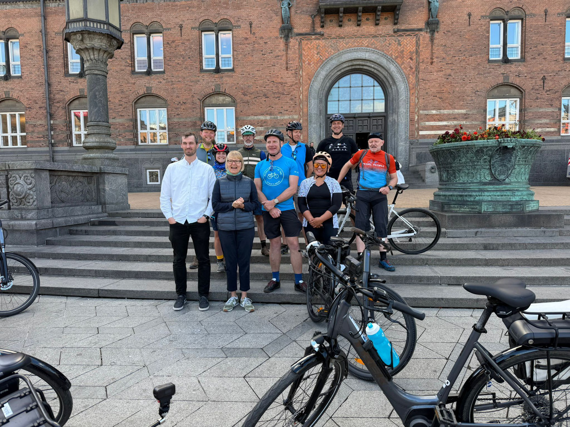 Personer som står på en trappa med cyklar i förgrunden.