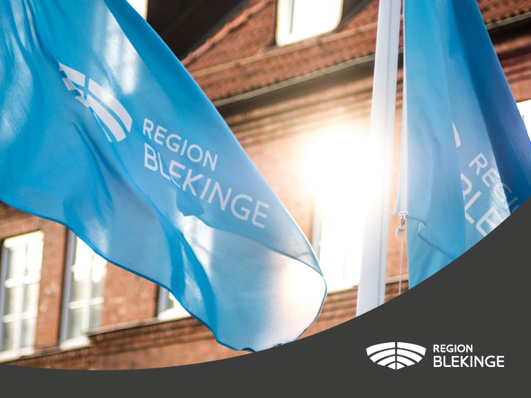 En närbild på blåa flaggor med Region Blekinges logotyp.