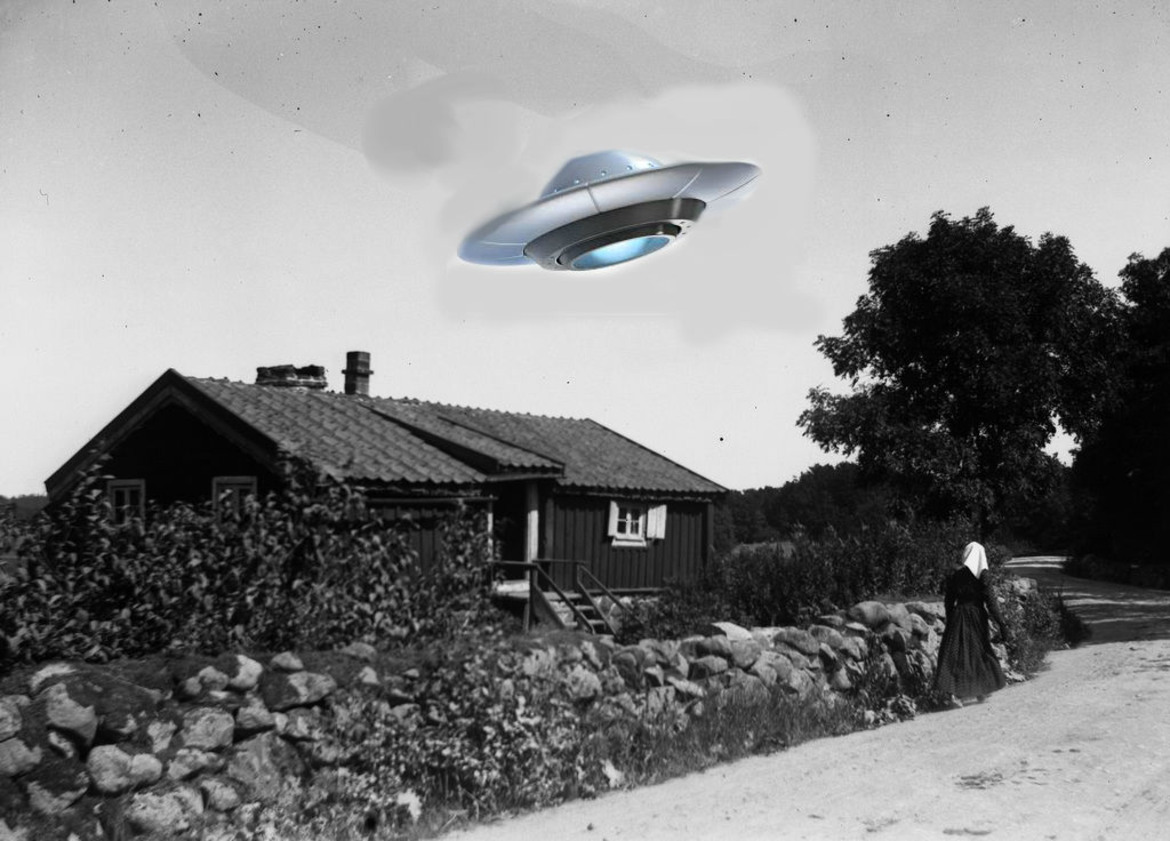 Äldre svartvitt foto föreställande stuga med stenmur framför och kvinna med huvudduk gående bakifrån, här bildredigerad med ett ufo flygande över