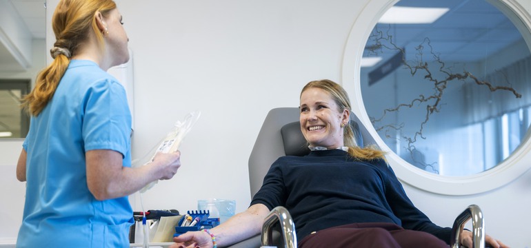 En patient pratar med en sjuksköterska inför blodgivning.