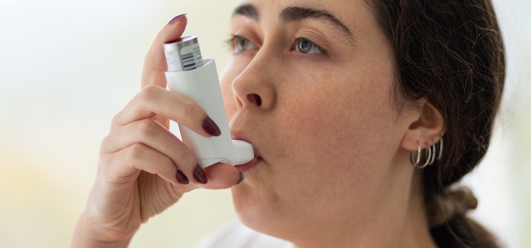 Bild på kvinna med inhalator. 