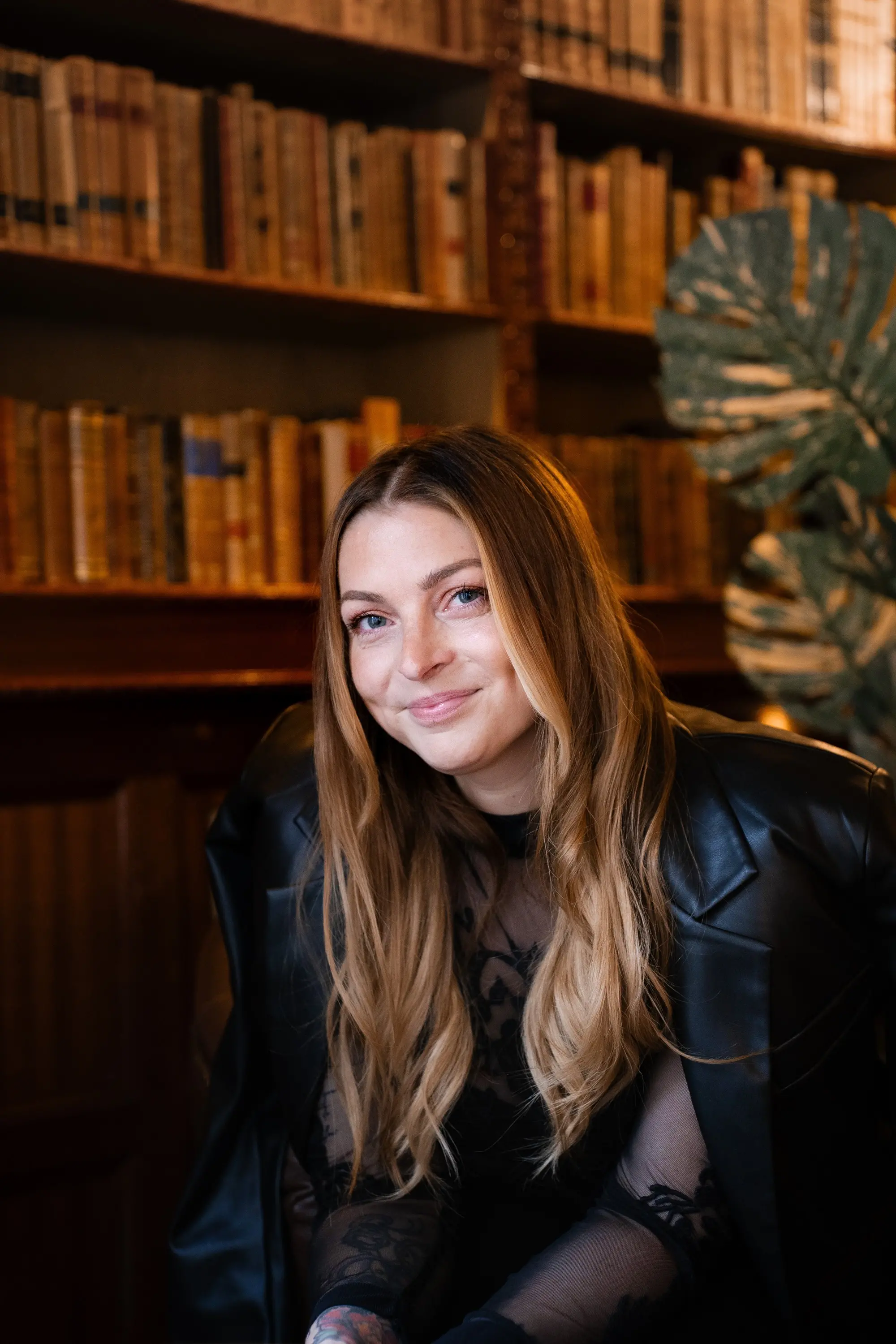 Paulina Ny sitter vid en bokhylla