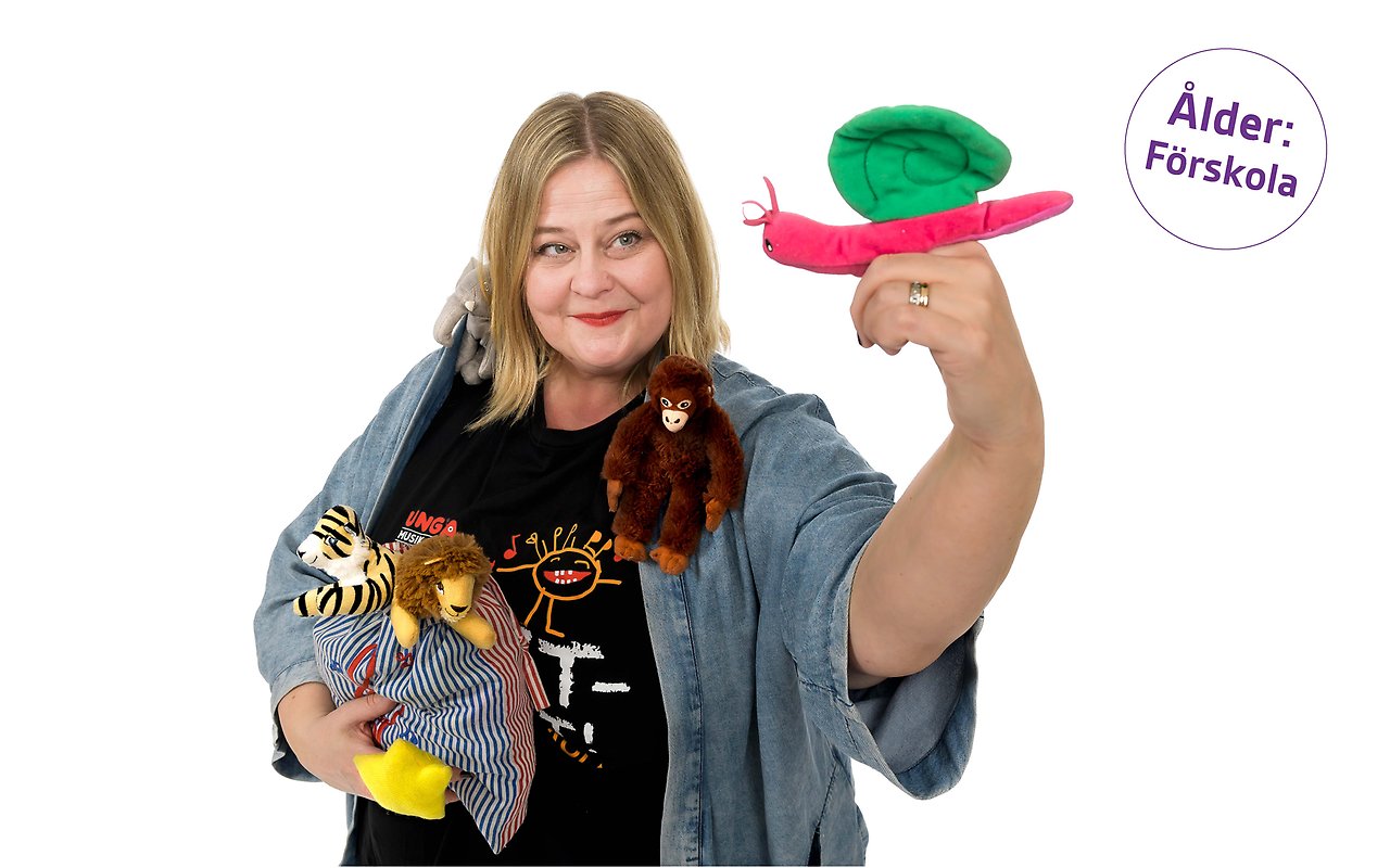 Porträtt av Elinor Fryklund med famnen full av små tygdjur i olika färger