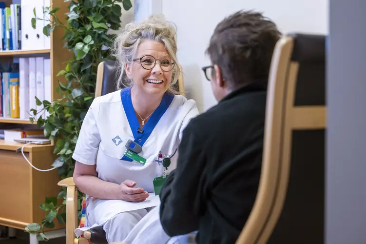 Sjuksköterska som samtalar med en patient.
